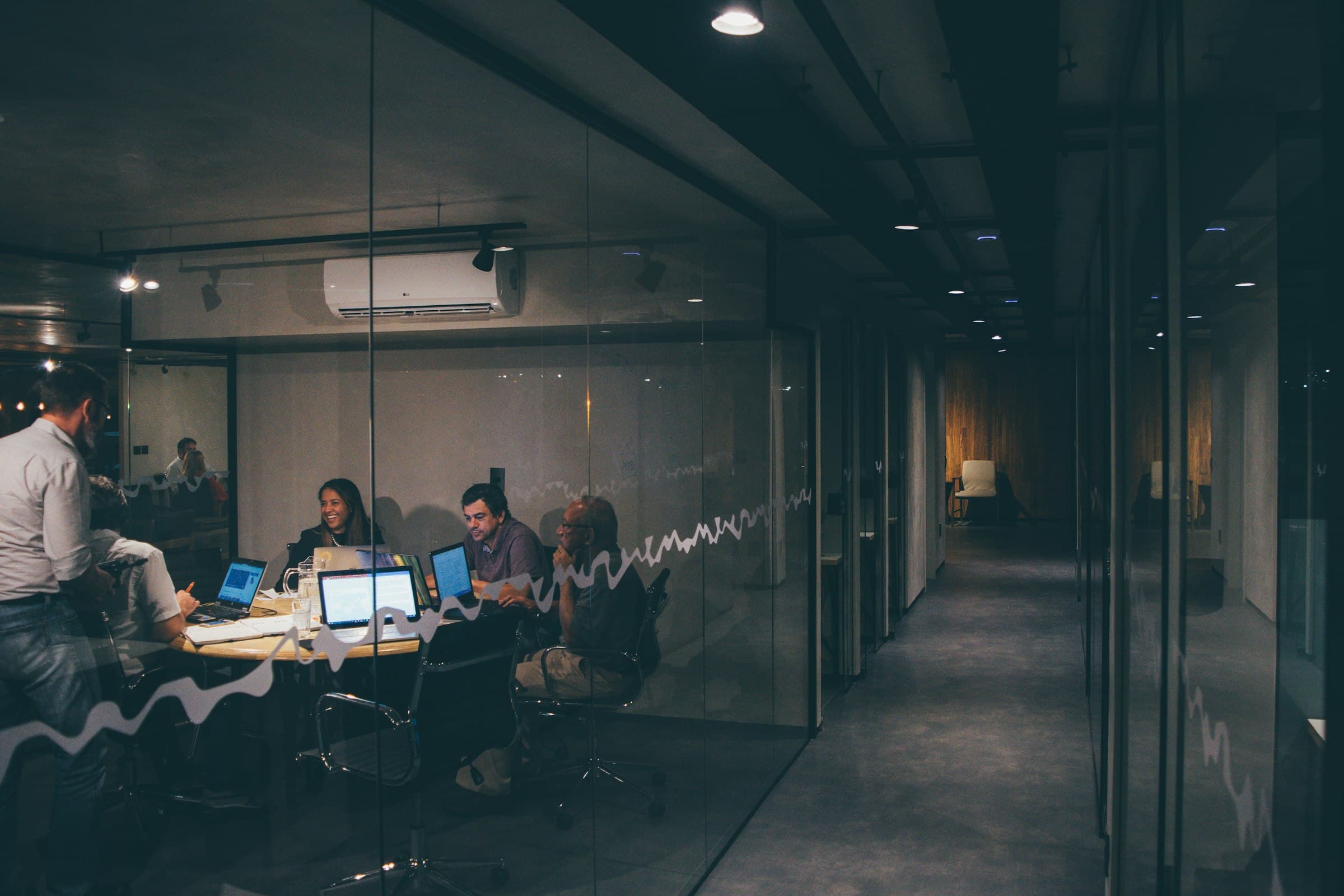 Corporate team working together in a modern glass-walled office