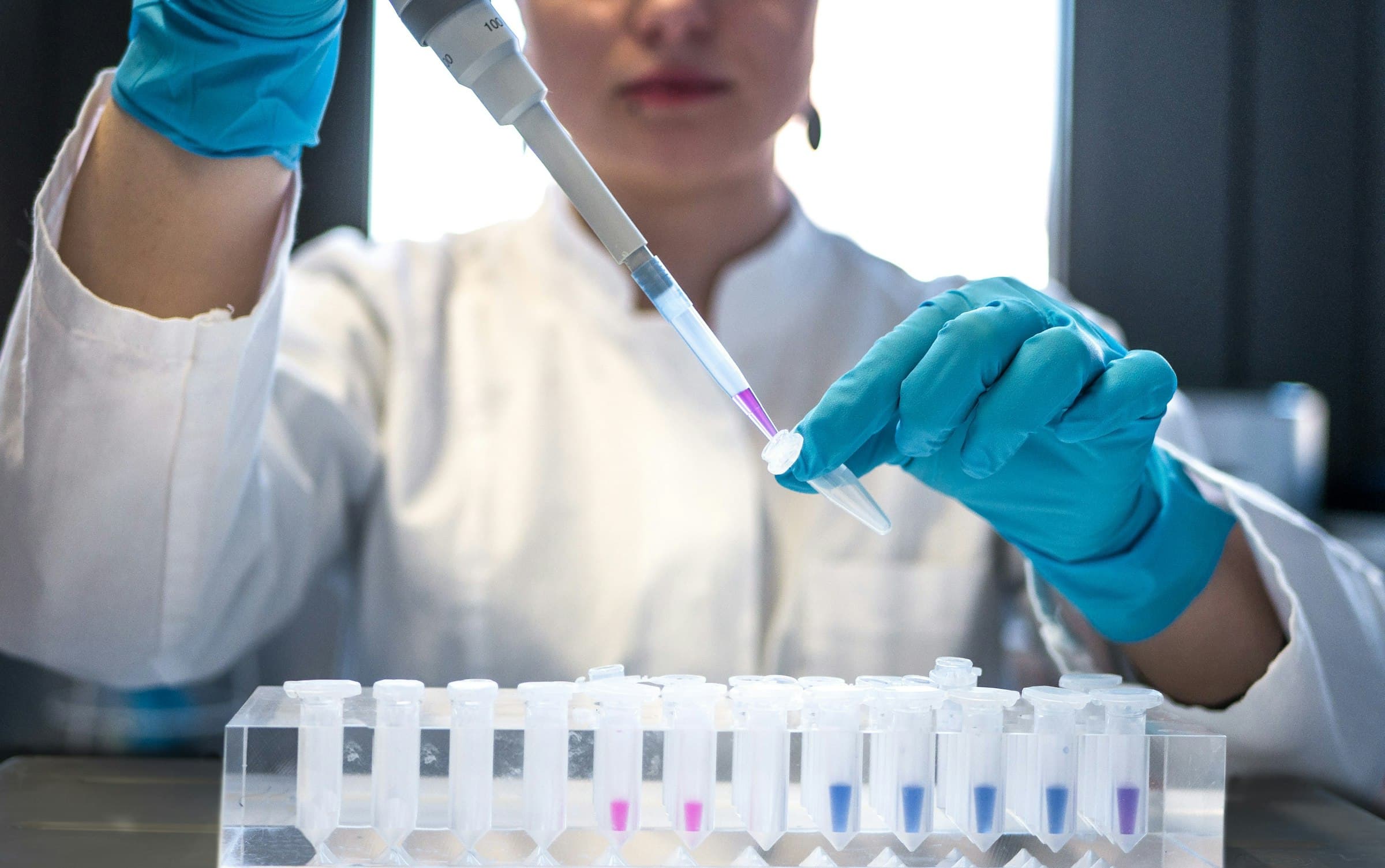 Scientist pipetting samples into test tubes in a laboratory